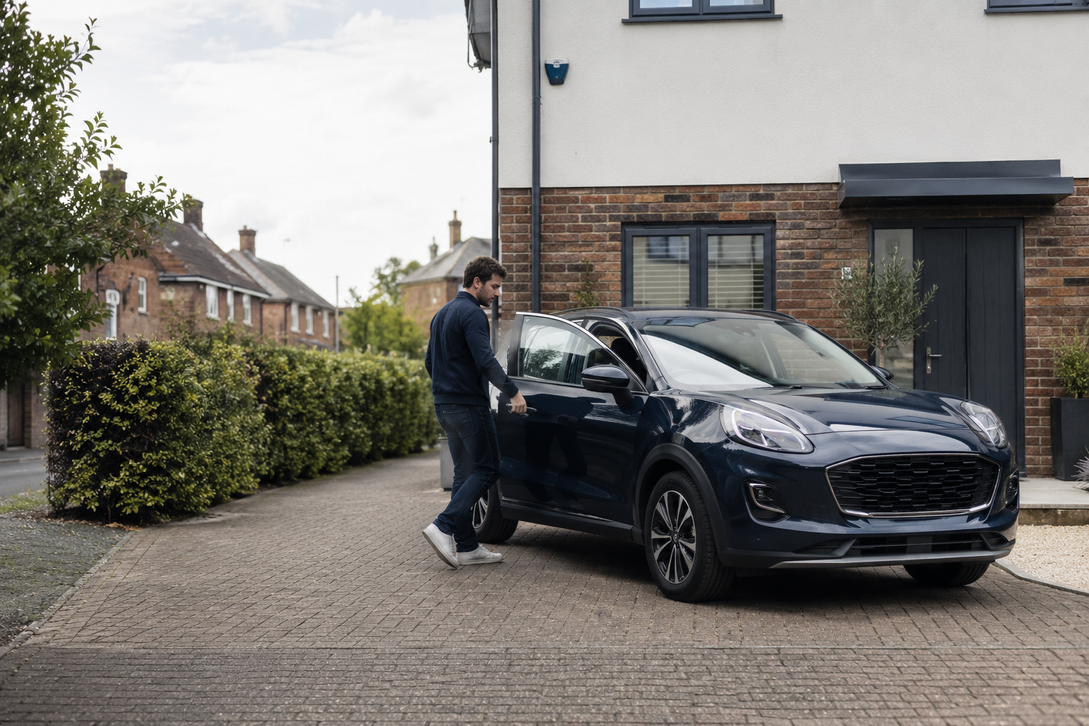 A driver getting into a dark blue family car on a British driveway
